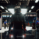 a driver stands in a garage in gran turismo 7